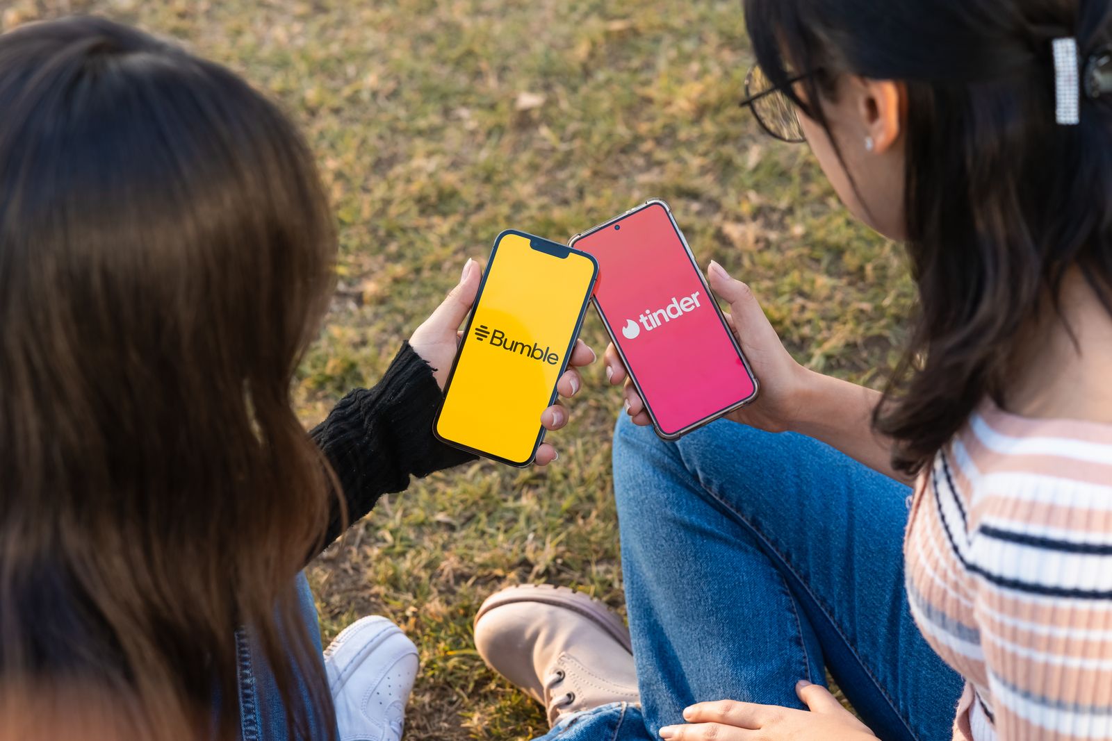 I loghi di Bumble e Tinder sugli schermi di due smartphone.